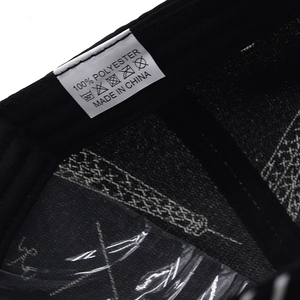 Macro view of 100% polyester care label and stitching inside the black baseball cap