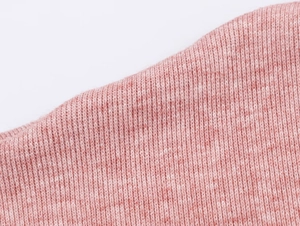 Gros plan sur le tissu en tricot rose montrant la texture côtelée de cet ensemble jupe