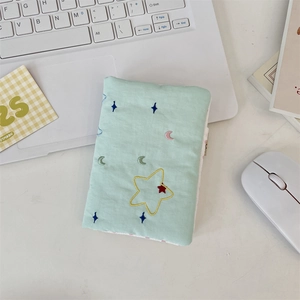 Close-up of quilted mint green travel passport holder with colorful star embroidery