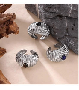 Detail of vintage textured silver rings with inlaid colorful gemstones on natural wood