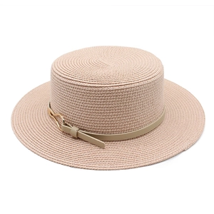 Detail of flat top straw sun hat with beige leather strap and gold buckle accent