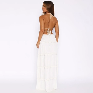 Rear view of white backless halter top and tiered maxi skirt set on studio background