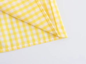 Close-up of yellow and white plaid fabric detailing the stitch quality and textile texture