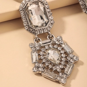 Macro shot of silver drop earrings with rectangle and teardrop crystals and fine pavé details