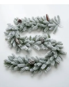 Détail de guirlande en PE enneigée avec pommes de pin pour décoration de Noël de table