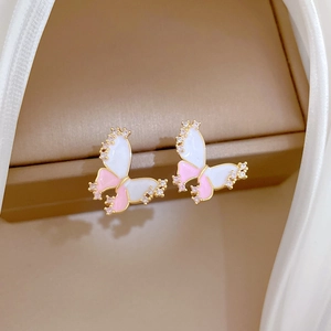 Detailed view of pink and white butterfly earrings with sparkling crystals in a gold frame