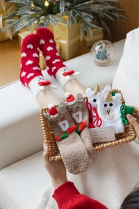 Detail of soft coral fleece Christmas socks featuring reindeer and heart patterns