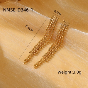 Elegantes pendientes de borla en acero inoxidable dorado con pedrería sobre fondo brillante