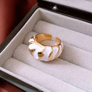 Adjustable gold and white enamel croissant ring displayed in a premium jewelry box
