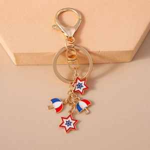 Detailed view of golden keychain with red blue umbrella and star enamel charms