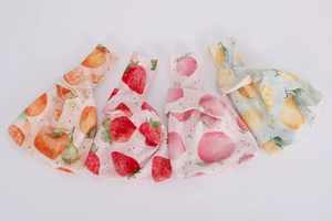 Detailed set of four velvet wrist bags with vibrant orange strawberry peach and lemon prints