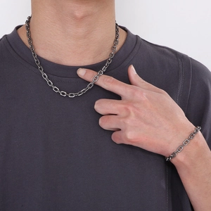 Close-up of minimalist stainless steel O-chain necklace and bracelet set on model