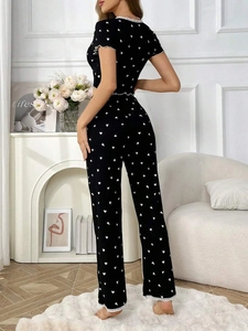 Detail of black heart-print pajama set featuring delicate white ruffle trim and lace edges