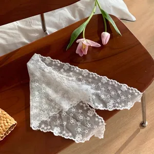 Close-up of white lace hair bandana with floral embroidery and scalloped edges