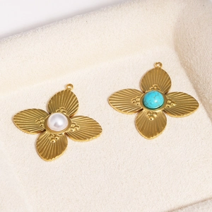 Close-up of gold clover pendants with pearl and turquoise inlays on beige velvet