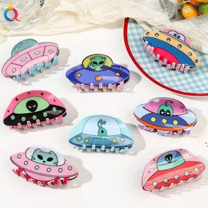 Detailed flat lay of acrylic UFO alien claw clips in various colors and fun patterns