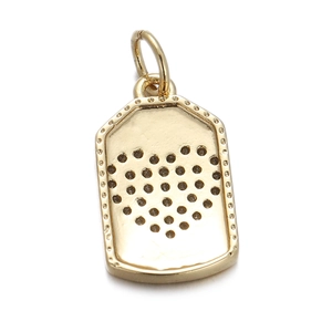 Detailed view of a gold rectangular metal pendant with a hollow heart-shaped pattern