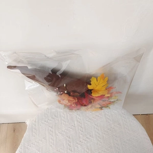 Detail of autumn wreath with orange and yellow flowers in transparent plastic packaging