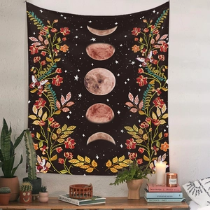 Detail of bohemian moon phase tapestry with floral patterns in a cozy room setting