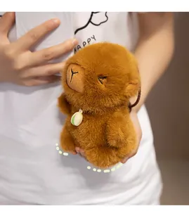 Detailed view of plush brown capybara keychain with green bean charm and soft fur texture