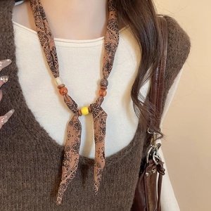 Detailed close-up of retro fabric beaded necklace with paisley patterns and resin beads