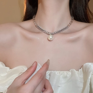 Detail shot of crystal beaded necklace with large white pearl pendant on neck