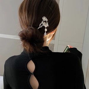 Épingle à cheveux fleur argentée avec perles et pompons sur une coiffure élégante