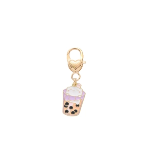 Golden enamel keychain featuring a cute white cat in a pink pearl milk tea cup