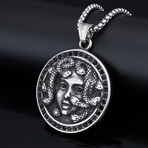 Macro view of vintage silver Medusa pendant with black rhinestones and wheat chain