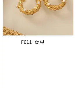 Détail de créoles dorées vintage texturées avec perles blanches et strass brillants