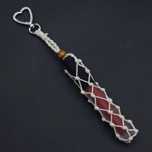 Detail of handcrafted woven lipstick holder with silver heart clasp and wooden bead
