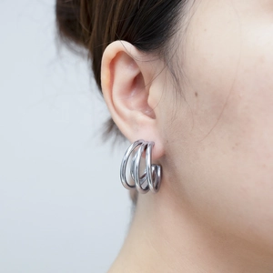 Nahaufnahme eines silbernen mehrlagigen Creolenohrrings im minimalistischen Design