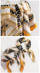 Detail showing leopard and chain print silk-like scarves in elegant gold and black