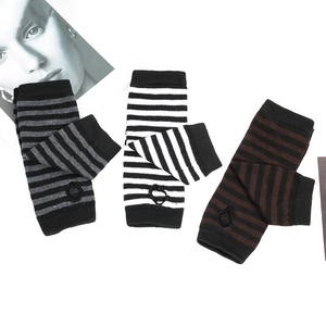 Flat lay of striped knitted fingerless arm sleeves in grey, white, and brown colors