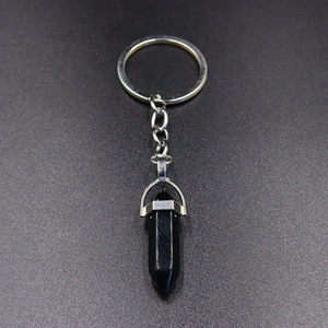 Detailed macro view of black obsidian hexagonal crystal bullet pendant keychain with silver link