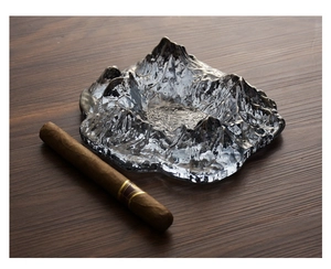 Macro shot of silver glacier textured glass cigar ashtray on premium wood surface