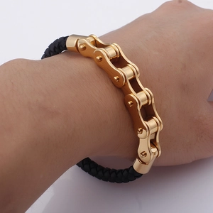 Nahaufnahme eines Lederarmbands im Biker-Stil mit goldenen Kettengliedern am Handgelenk