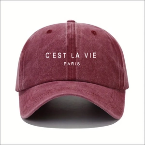 Detail shot of the Paris text embroidery on a washed dark red adjustable baseball cap