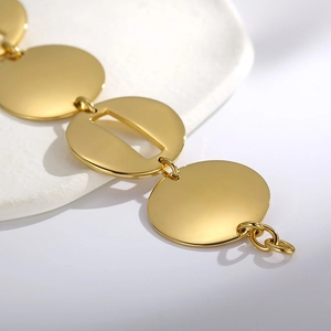 Dettaglio macro dei dischi dorati lucidi del bracciale in acciaio inossidabile