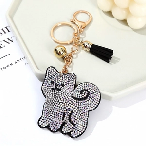 Cute Shiba Inu rhinestone keychain with black tassel and golden bell on a white tray