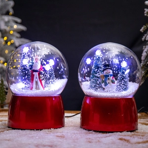 Christmas snow globe decorations with Santa and Snowman figures on red metal bases