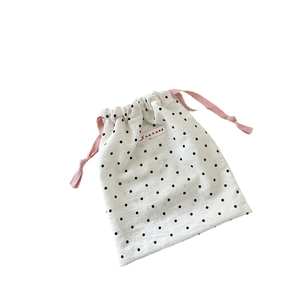 Three-piece set of white polka dot drawstring storage bags with pink woven cords