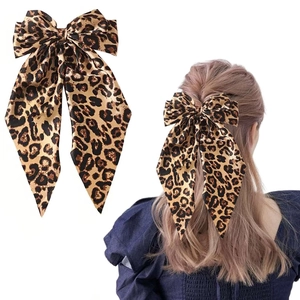 Detail of leopard print satin bow hair clip with long streamers on model hairstyle