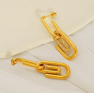 Gros plan de boucles d'oreilles trombone dorées avec pavé de cristaux luxueux