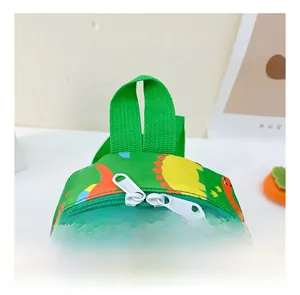 Detail of the green kids backpack featuring orange dinosaur prints and double zippers