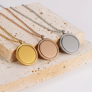 Set of three spinning round pendant necklaces in gold, rose gold and silver on a stone