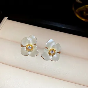 Elegant gold-plated flower stud earrings with white petals and a central zircon stone