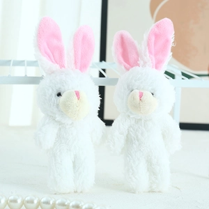 Close-up of white plush bunny toys with pink inner ears and soft long fur texture