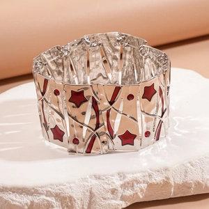 Detail of silver stretch bracelet with red star patterns and rhinestones on stone