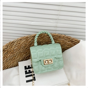 Detailed close-up of mint green quilted jelly bag with golden lock and chain strap